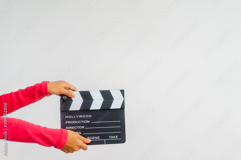 Kid hands holding clapper board for making video cinema in studio.Movie production clapper board or 
