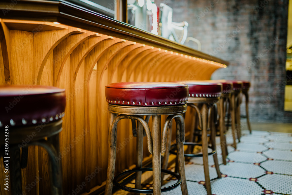 红色凳子椅和饮酒场所。酒吧、咖啡馆或酒吧内部。柜台酒吧。复古凳子
