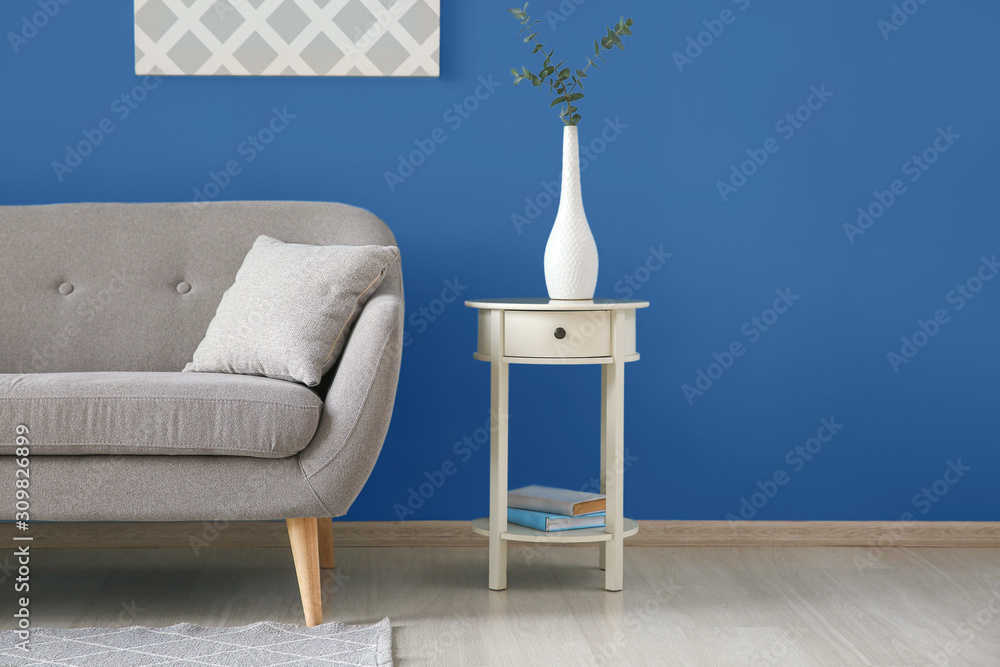 现代房间内部，靠近蓝色墙壁，配有舒适的沙发和桌子