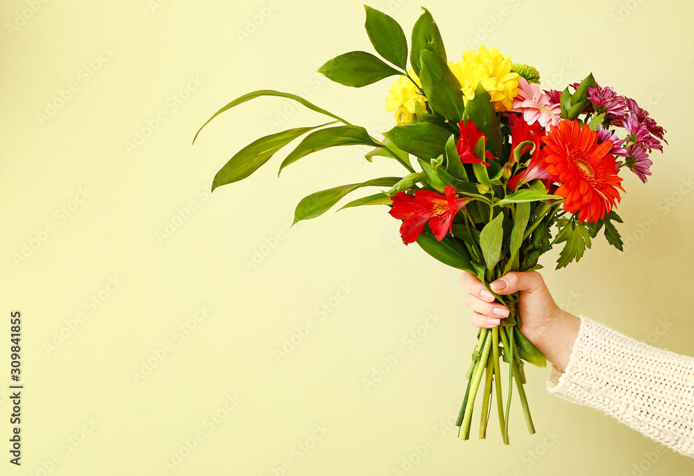 彩色背景上有美丽花束的花商之手