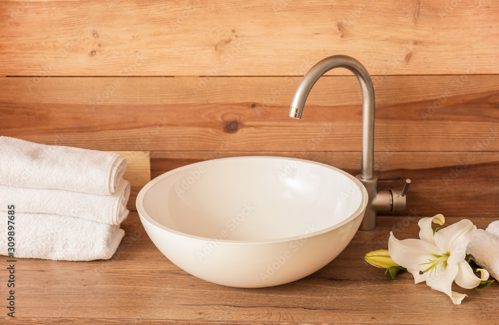 Interior of clean bathroom with sink near wooden wall