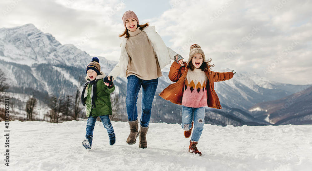 快乐的家庭妈妈和孩子们在冬天散步时玩得很开心。