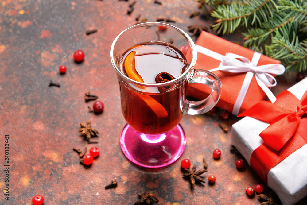 桌上摆着一杯美味的热葡萄酒、圣诞礼物和杉枝