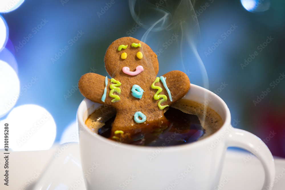 姜饼饼干男在一杯圣诞背景的热咖啡里洗澡