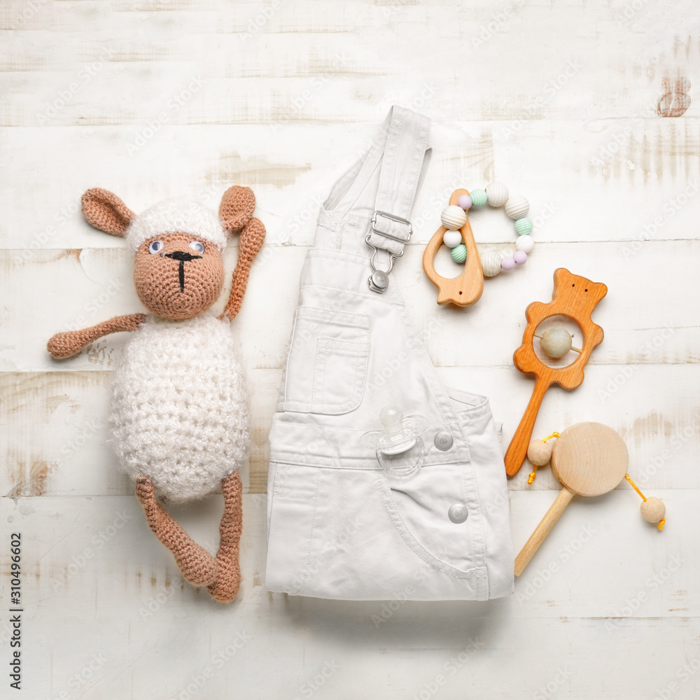白色木制背景的婴儿衣服和玩具
