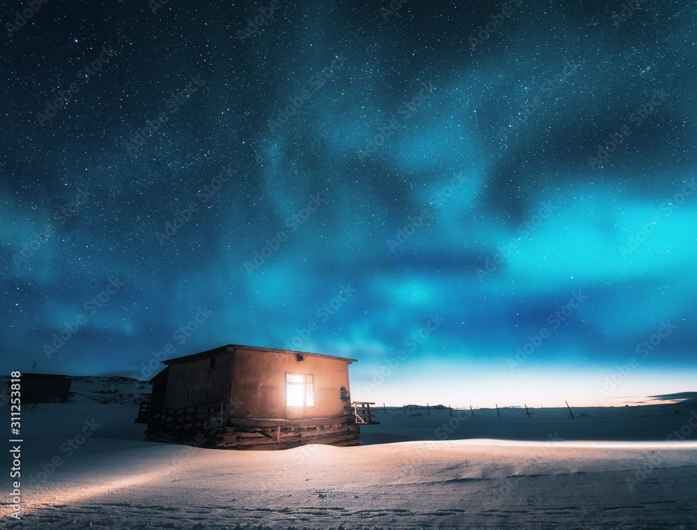 冬天，北极光从窗户照射到古老的小房子上。Teribe的北极光