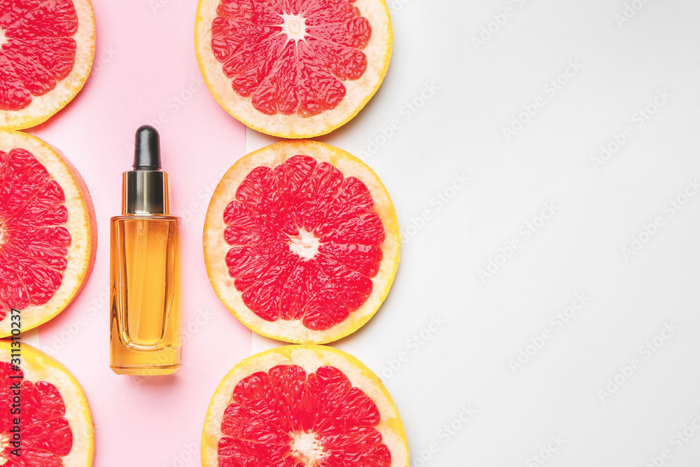 一瓶精油和葡萄柚片，颜色背景