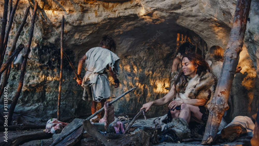 披着兽皮的猎人部落住在洞穴里。首领从狩猎中带来猎物
