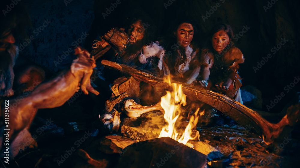 尼安德特人或智人家族在篝火上烹饪动物肉，然后食用。史前部落