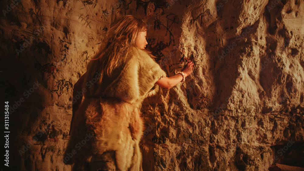 一个穿着动物皮的原始史前尼安德特人儿童的后视图画动物并在上面抽象