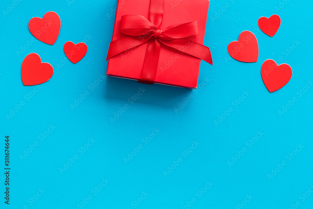 情人节送给爱人的礼物。蓝色背景下的红心礼盒自上而下的警察