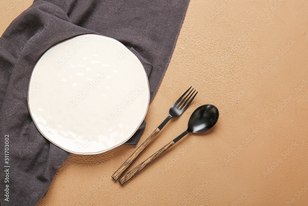 彩色背景上的空盘子、餐巾和餐具
