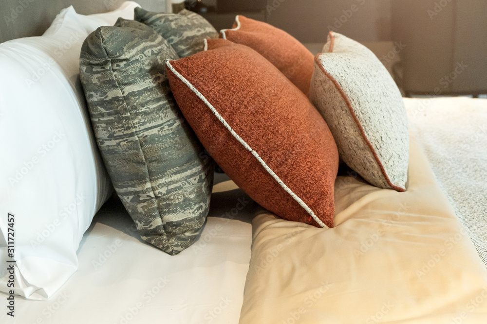 现代卧室设计理念中美丽的柔软枕头和毯子与白色舒适的床