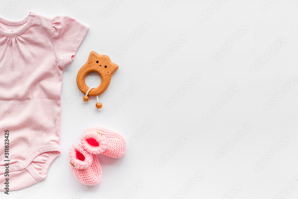 婴儿背景-粉红色。白色桌面d上新生儿女孩的衣服、短靴和配饰