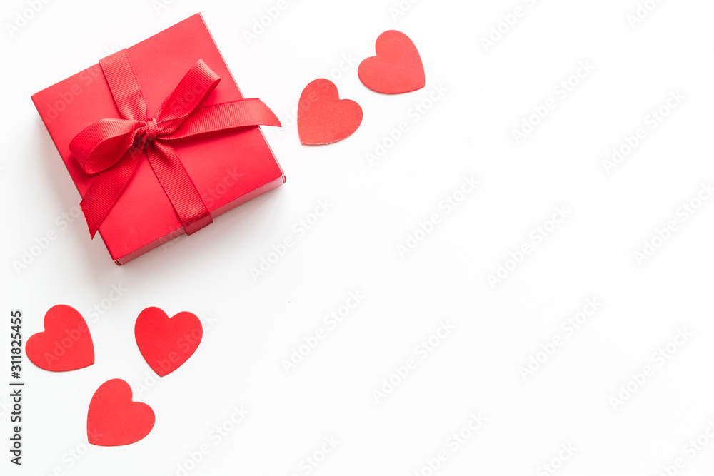 情人节送给爱人的礼物。白色背景上靠近心形的红色礼物盒自上而下。