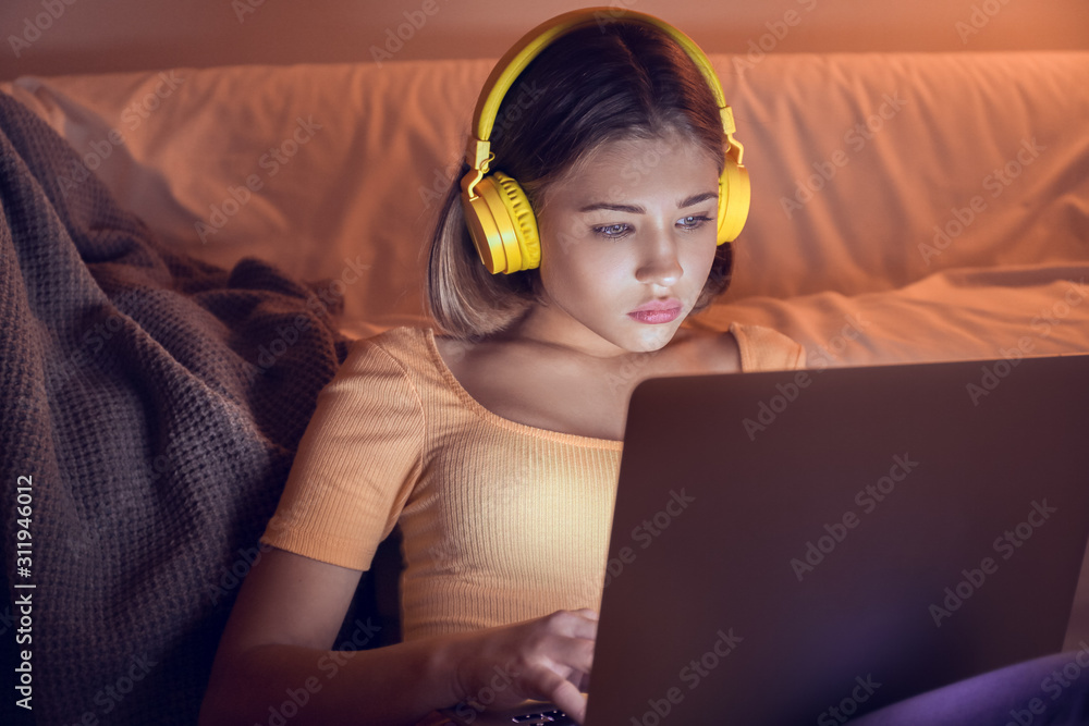 深夜拿着笔记本电脑听音乐的少女