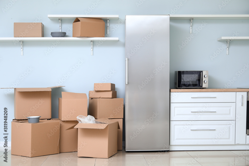 搬家日新公寓厨房里的纸板箱，里面有物品和冰箱