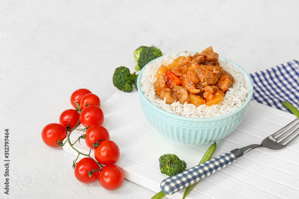 白桌上有美味的米饭、鸡肉和蔬菜的碗