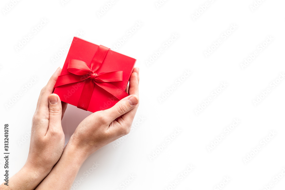在情人节送一份礼物。女人们手拿白色背景的漂亮的红色礼物盒。