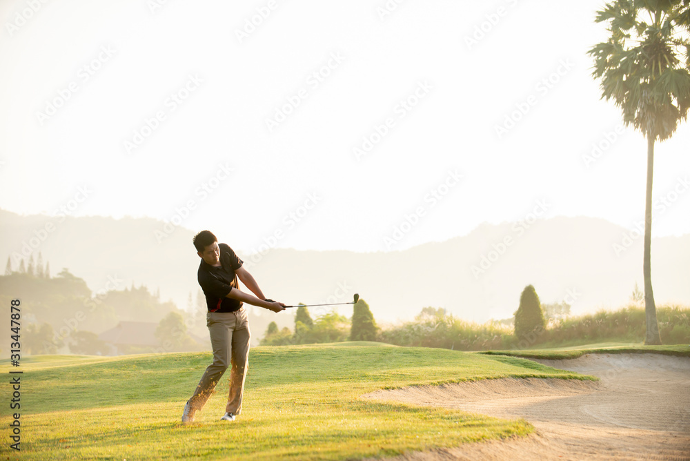 亚洲男子高尔夫球手在高尔夫球场打高尔夫