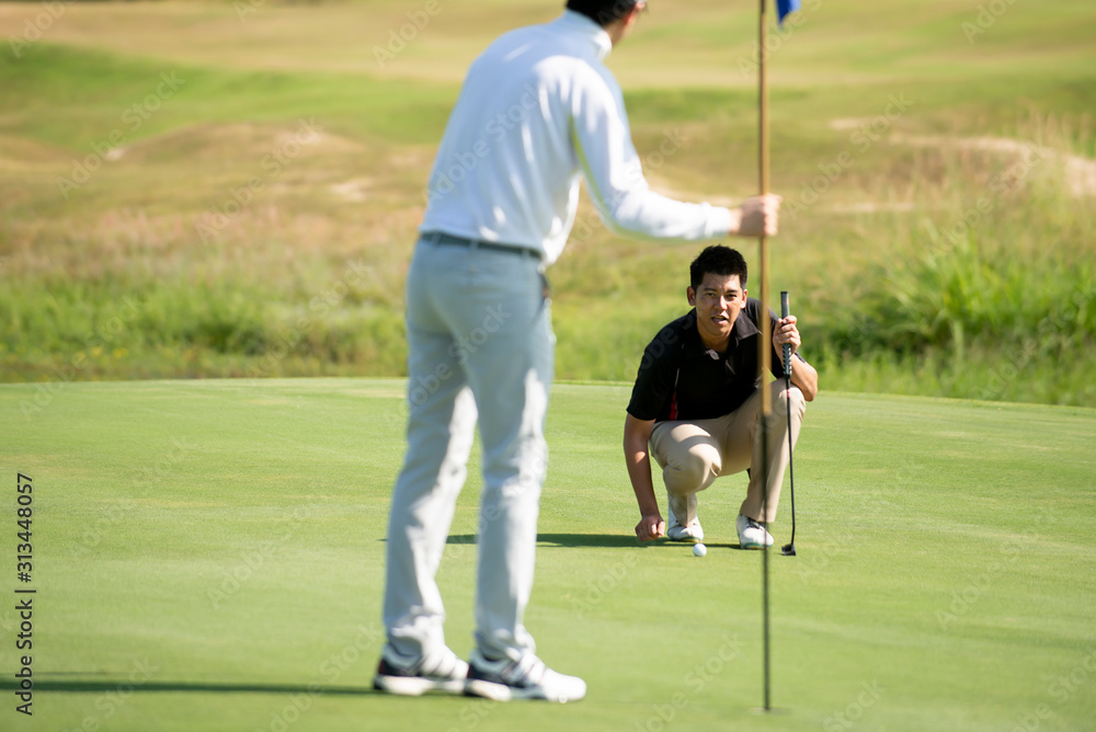 两名亚洲男子高尔夫球手将高尔夫球瞄准高尔夫球场