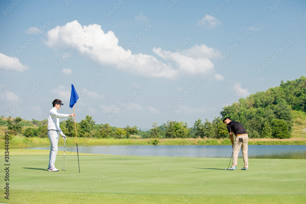 两名亚洲男子高尔夫球手在高尔夫球场打高尔夫