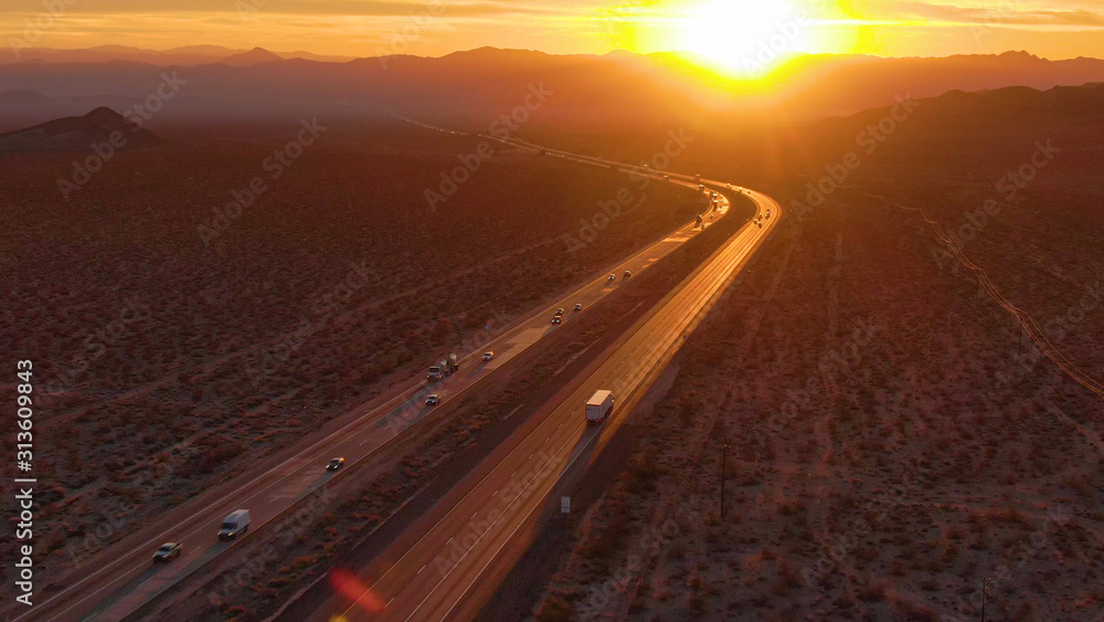 空中飞行：日落时分，在穿越莫哈韦沙漠的卡车和汽车上方飞行。