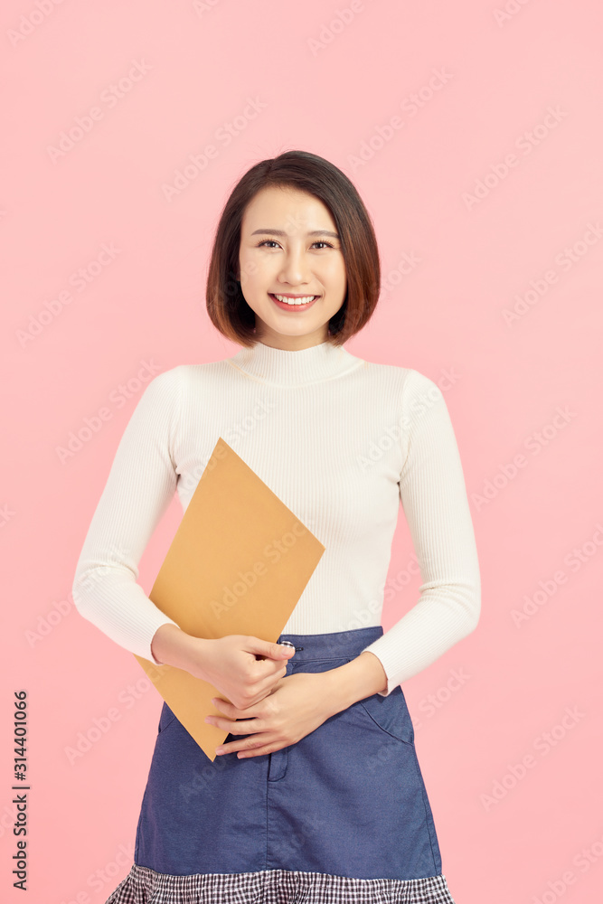 Young Asian business woman holding a file, isolated on pink background