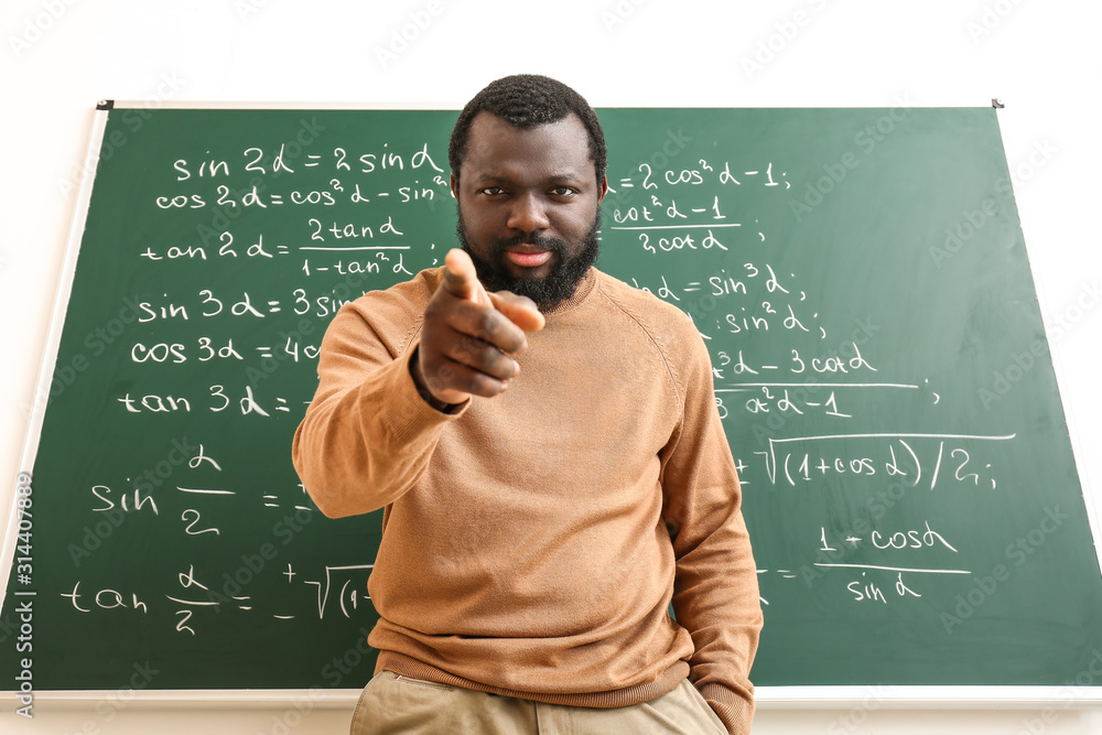 愤怒的非裔美国数学老师靠近教室黑板