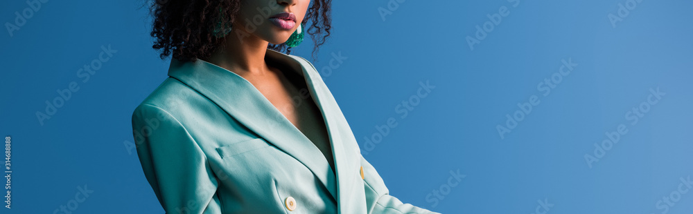 穿着西装的非裔美国妇女在蓝色隔离的全景照片