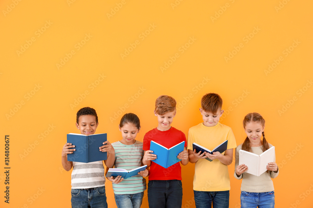 可爱的小孩在彩色背景下看书