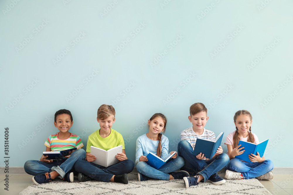 可爱的小孩在彩色背景下看书