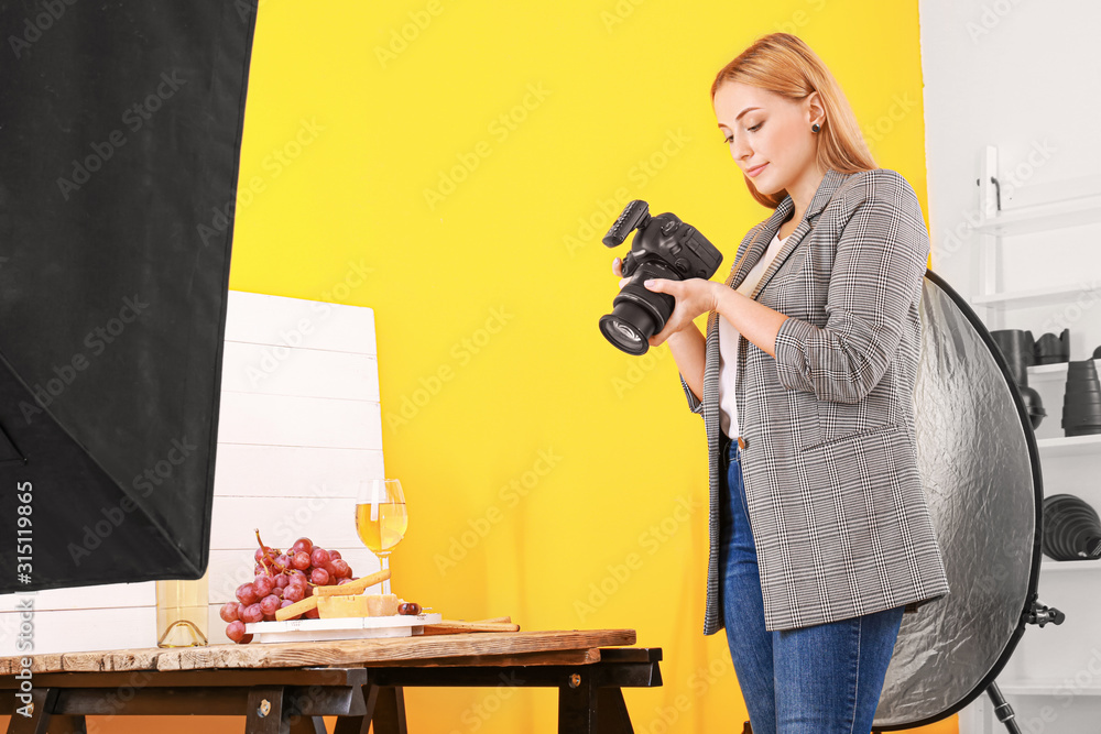 年轻女子在专业工作室拍摄奶酪和葡萄酒的照片