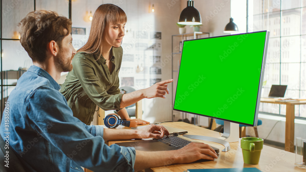女艺术总监咨询设计师同事，他们在带绿屏的个人电脑上工作