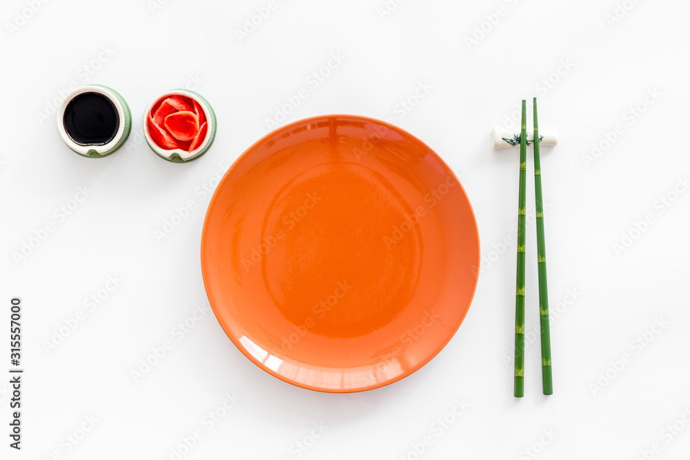 寿司和卷的餐具。盘子、筷子、小碗、生姜和白背锅炒菜