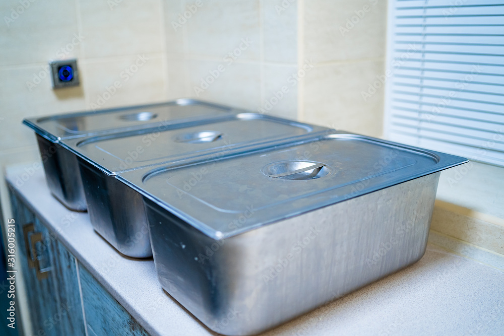 Metal box containers with cover up. Food processing process. Kitchen utensils. Closeup