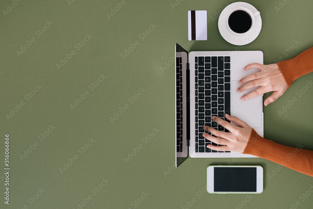 女性用黑色键盘在白色笔记本电脑上打字