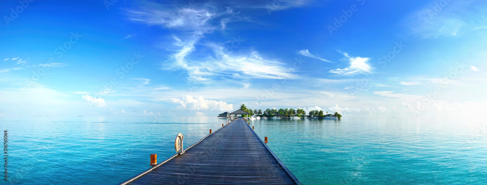 Beautiful tropical landscape background, concept for summer travel and vacation. Wooden pier to an i