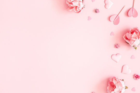 情人节背景。粉色花朵，信封，淡粉色背景上的心形。情人节