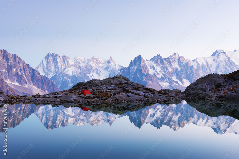 法国阿尔卑斯山脉布兰科湖海岸的红色帐篷。背景是比安科山脉。Landsca