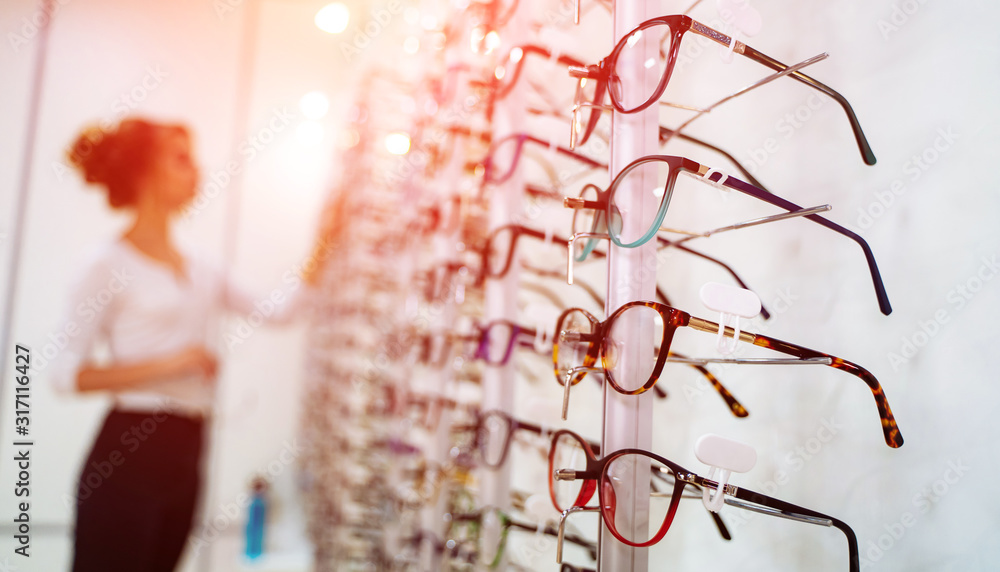 眼镜店的一排眼镜。眼镜店。在眼镜店戴着眼镜站着。女人ch