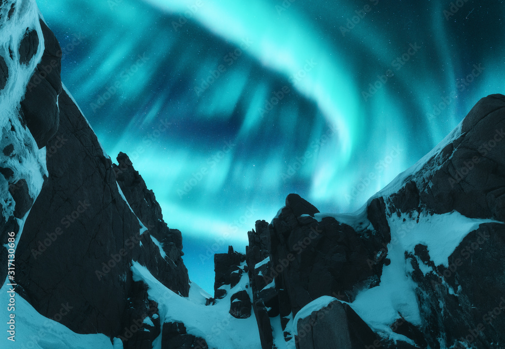 挪威罗弗敦群岛白雪皑皑的山峰上的北极光。w中的北极光