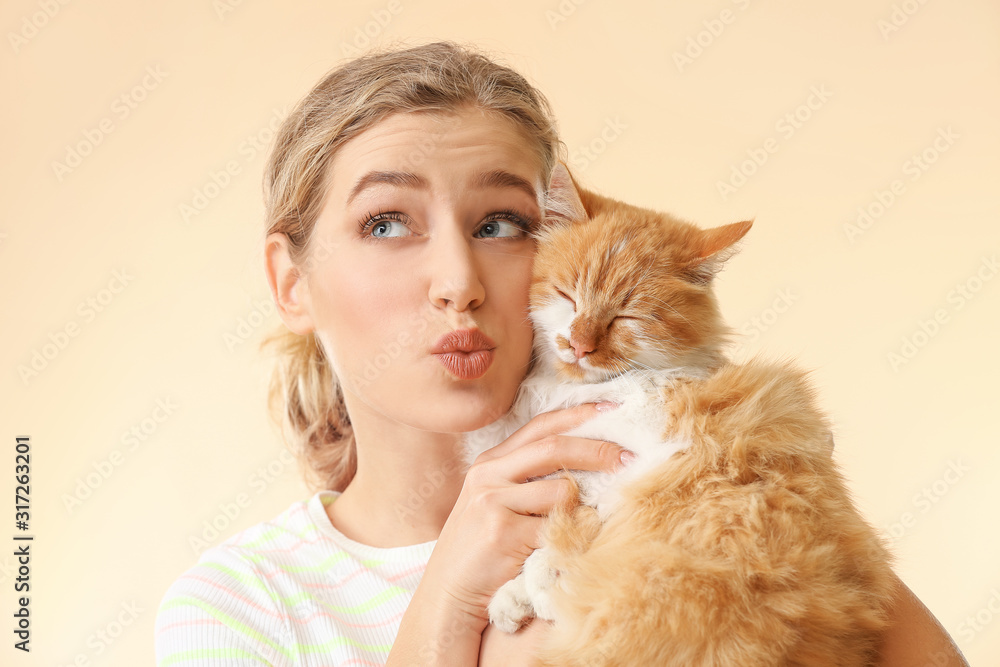 美丽的年轻女人，彩色背景上有可爱的猫