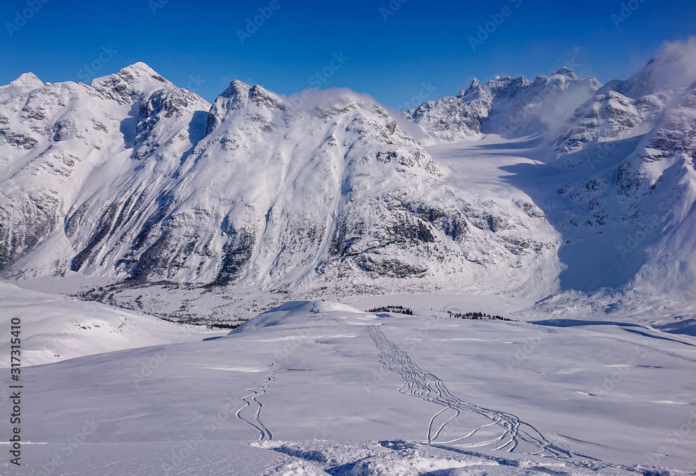 一群直升机乘客在覆盖落基山脉的新雪中留下了踪迹。