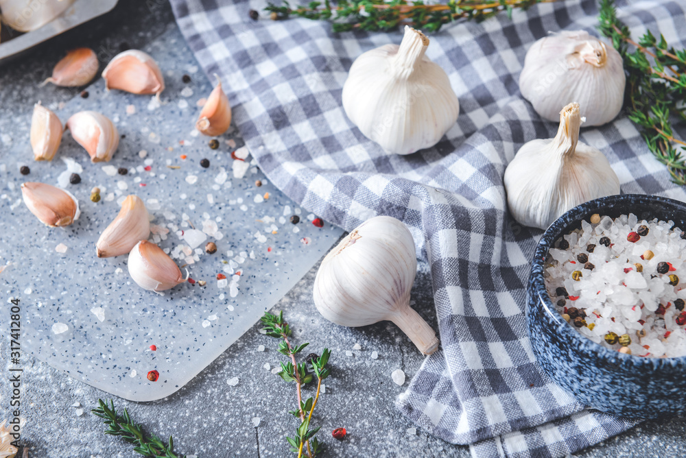 Fresh garlic with spices and herbs on grey background