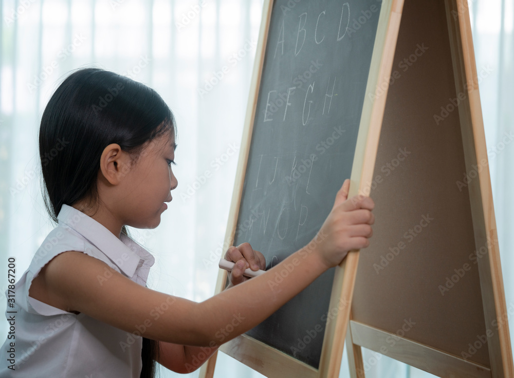 亚洲女孩在回到学校之前在篮板上写字和做家务