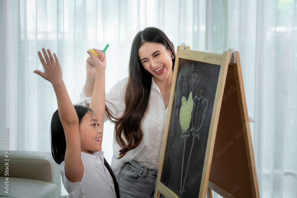亚洲老师教她的学生在黑板上画一朵花