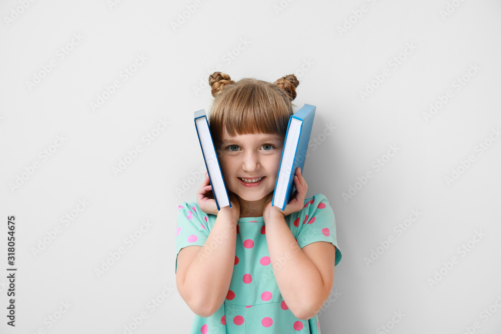 浅色背景下有书的可爱小女孩