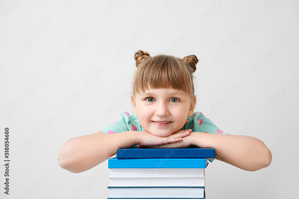 浅色背景下有书的可爱小女孩