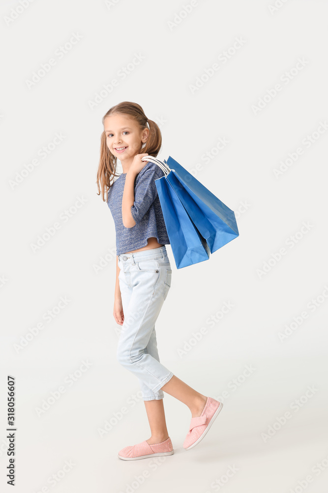 白色背景带购物袋的可爱小女孩